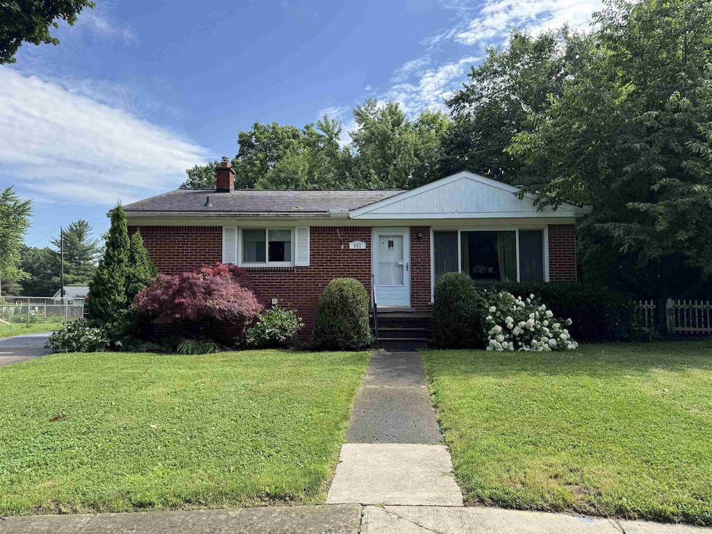 652 Lincoln Ct, Lapeer, MI 48446 - ranch-style house with brick siding, a front lawn, and a chimney