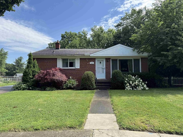 652 Lincoln Ct, Lapeer, MI 48446 - ranch-style house with brick siding, a front lawn, and a chimney