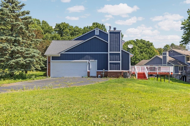 2017 Cumberland Dr, Brighton, MI 48114 - rear view of house with driveway, a chimney, a lawn, an attached garage, and a deck