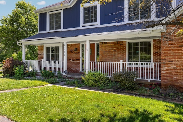 2017 Cumberland Dr, Brighton, MI 48114 - traditional home with a porch, a front yard, and brick siding