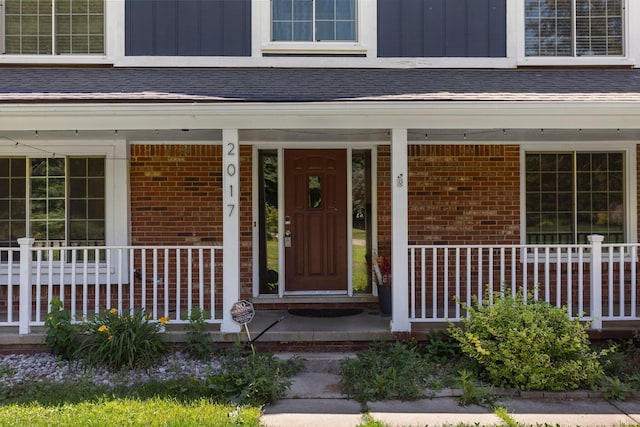 2017 Cumberland Dr, Brighton, MI 48114 - view of exterior entry with a porch, brick siding, and board and batten siding