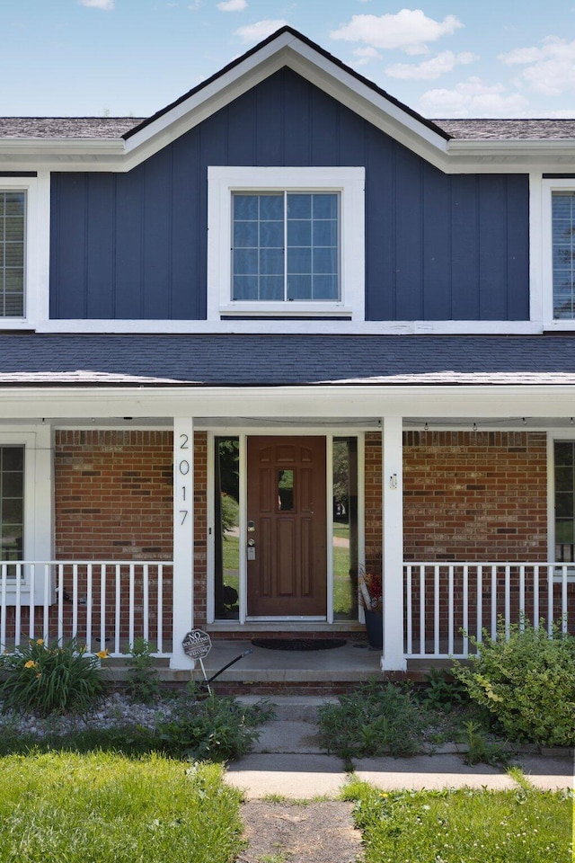 2017 Cumberland Dr, Brighton, MI 48114 - view of front of property featuring board and batten siding, a porch, and brick siding