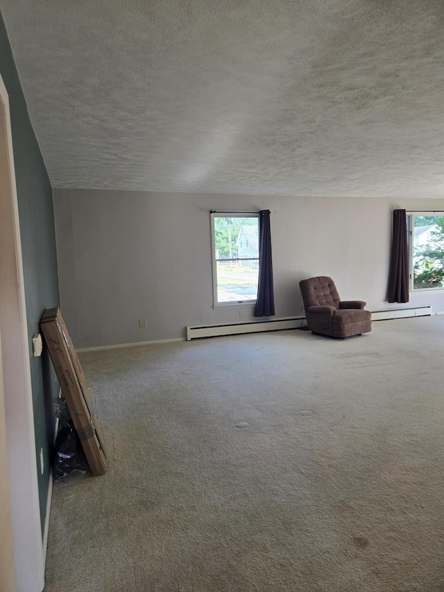 505 N Pine St, Evart, MI 49631 - unfurnished room with a textured ceiling, a baseboard radiator, and carpet flooring