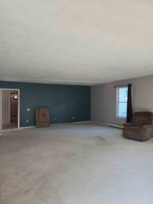 505 N Pine St, Evart, MI 49631 - unfurnished living room with baseboard heating, light colored carpet, and a textured ceiling