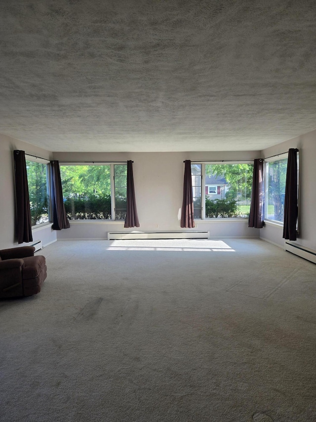 505 N Pine St, Evart, MI 49631 - unfurnished living room with carpet flooring, a baseboard radiator, and a textured ceiling