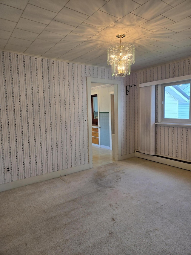 505 N Pine St, Evart, MI 49631 - carpeted spare room with wallpapered walls, a chandelier, and a baseboard radiator