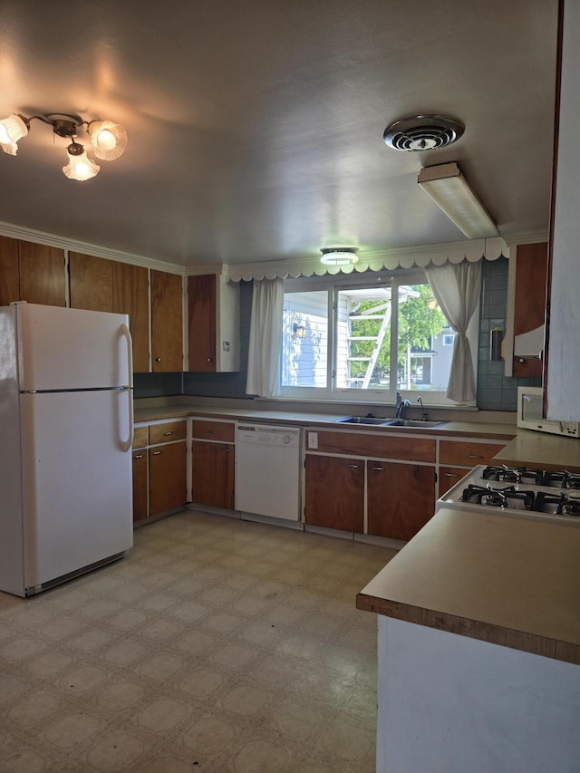 505 N Pine St, Evart, MI 49631 - kitchen featuring white appliances, light floors, and brown cabinets