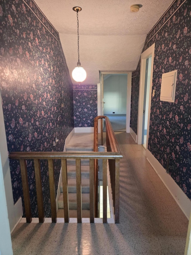505 N Pine St, Evart, MI 49631 - stairway with wallpapered walls, lofted ceiling, a textured ceiling, and electric panel