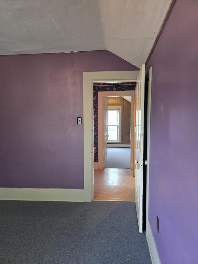 505 N Pine St, Evart, MI 49631 - corridor with vaulted ceiling, carpet floors, and a baseboard heating unit