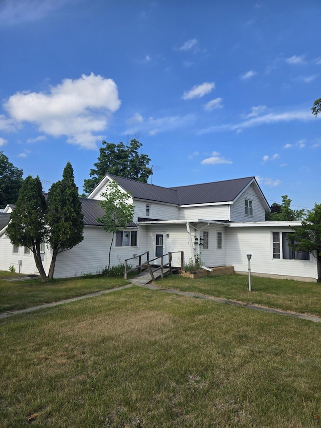 505 N Pine St, Evart, MI 49631 - view of front of property with a front lawn and a metal roof