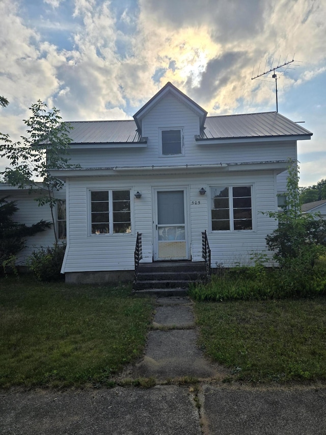 505 N Pine St, Evart, MI 49631 - bungalow-style home with entry steps, a metal roof, and a front yard