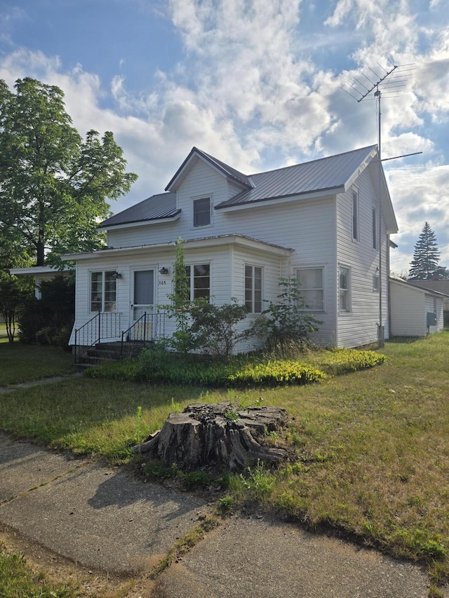 505 N Pine St, Evart, MI 49631 - view of front of property featuring a metal roof and a front yard