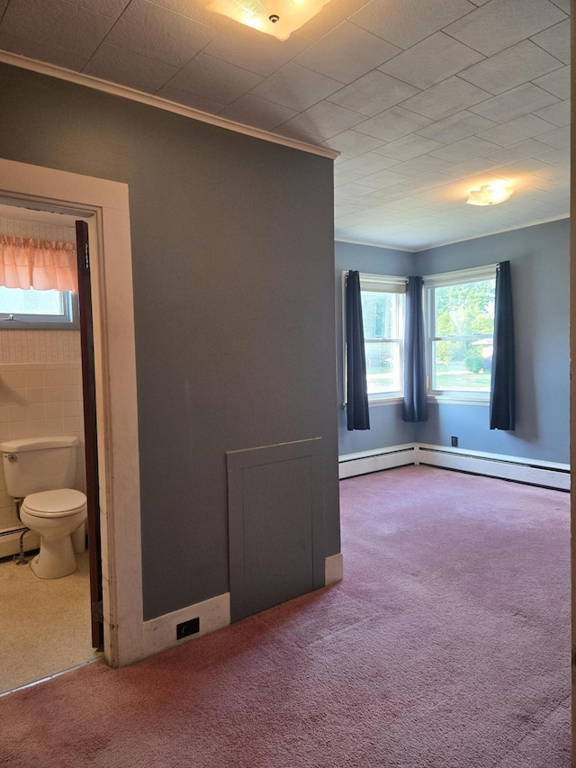 505 N Pine St, Evart, MI 49631 - spare room with ornamental molding, healthy amount of natural light, carpet floors, and a baseboard heating unit