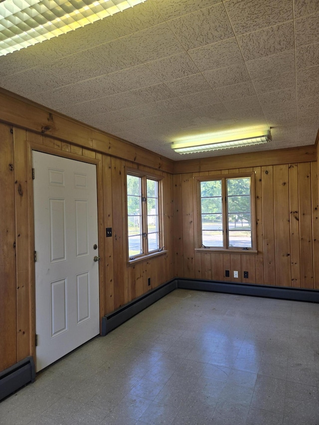 505 N Pine St, Evart, MI 49631 - foyer entrance with light flooring, wood walls, and a baseboard radiator