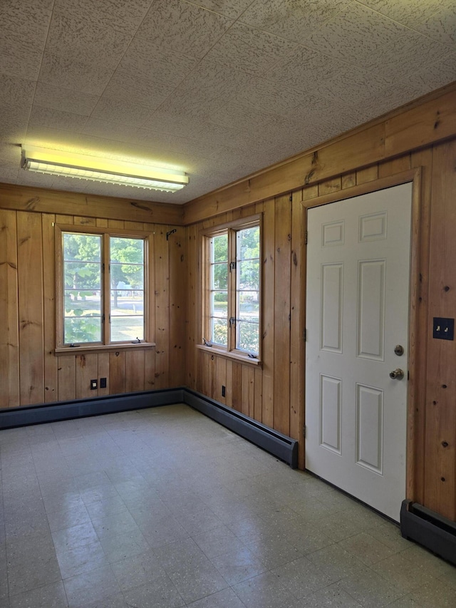 505 N Pine St, Evart, MI 49631 - unfurnished room with tile patterned floors, wooden walls, and plenty of natural light