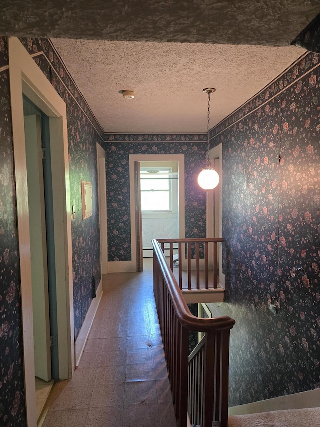 505 N Pine St, Evart, MI 49631 - hallway featuring wallpapered walls, tile patterned floors, a textured ceiling, and an upstairs landing