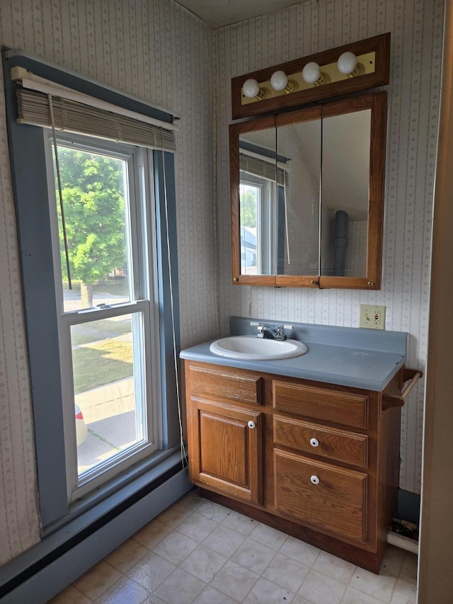 505 N Pine St, Evart, MI 49631 - bathroom featuring vanity, wallpapered walls, and a baseboard heating unit
