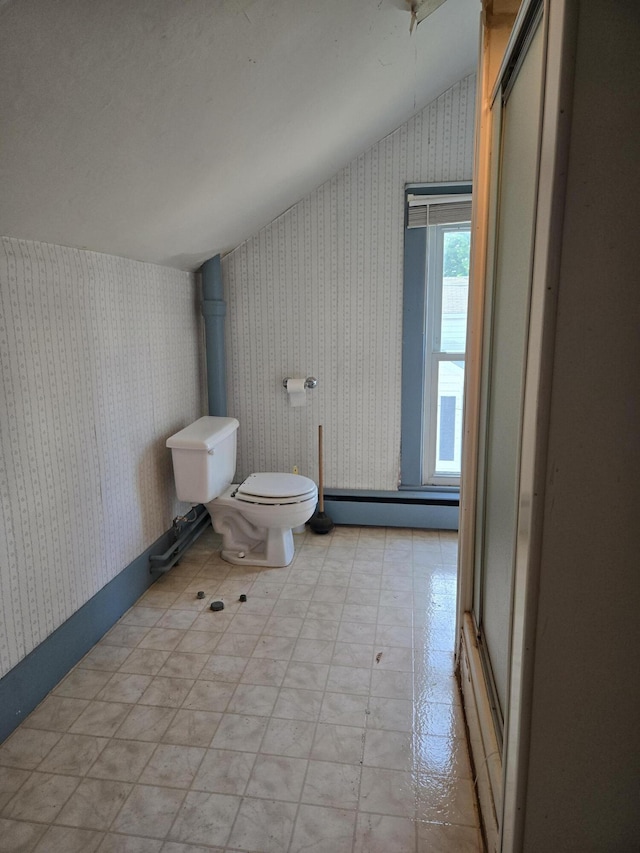 505 N Pine St, Evart, MI 49631 - bathroom featuring wallpapered walls, a baseboard heating unit, vaulted ceiling, and tile patterned floors
