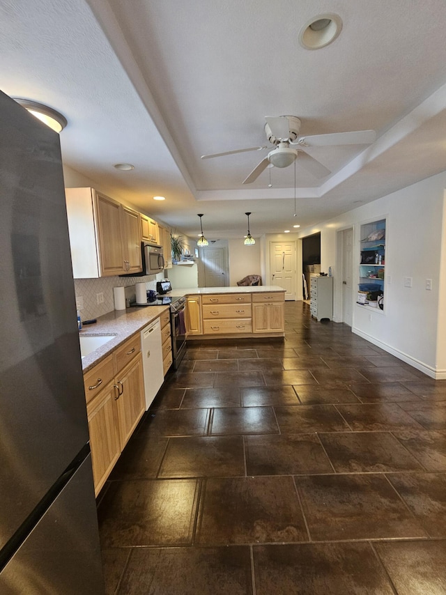 227 W Nelson St, Hastings, MI 49058 - kitchen featuring appliances with stainless steel finishes, a peninsula, a tray ceiling, light countertops, and recessed lighting
