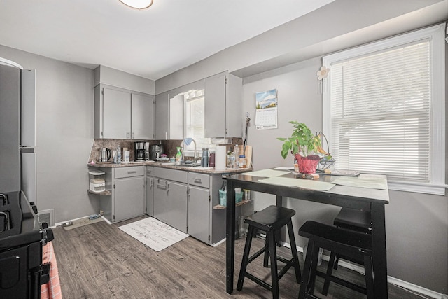 2620 Charlesgate Ave SW, Wyoming, MI 49509 - kitchen featuring gray cabinetry, dark wood finished floors, backsplash, light countertops, and freestanding refrigerator