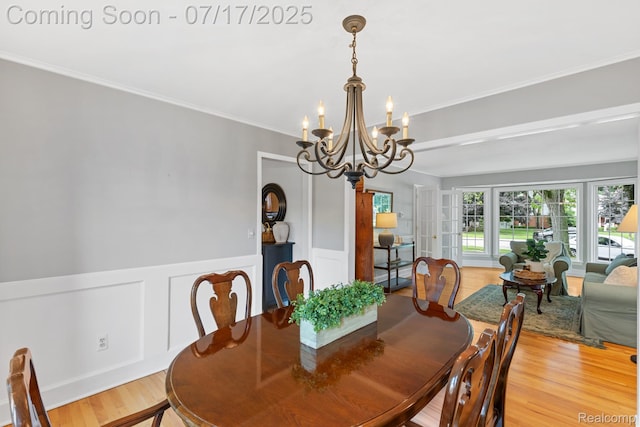 455 Leicester St, Plymouth, MI 48170 - dining area with a chandelier, light wood-style flooring, a wainscoted wall, ornamental molding, and a decorative wall