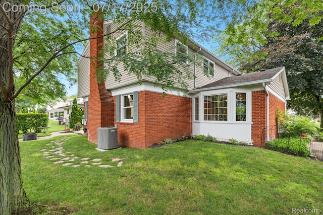 455 Leicester St, Plymouth, MI 48170 - view of property exterior with a chimney, brick siding, and a lawn