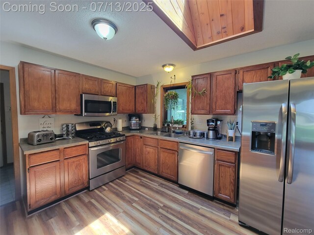 14373 Racho Blvd, Taylor, MI 48180 - kitchen featuring appliances with stainless steel finishes, brown cabinetry, light wood-style flooring, and light countertops