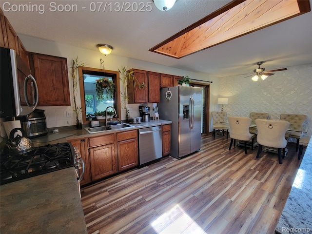 14373 Racho Blvd, Taylor, MI 48180 - kitchen featuring appliances with stainless steel finishes, light wood-style floors, ceiling fan, and brown cabinets