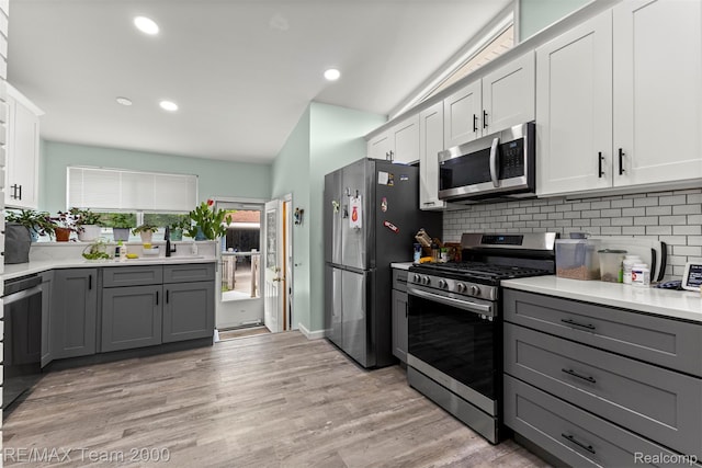 7396 N Charlesworth St, Dearborn Heights, MI 48127 - kitchen with appliances with stainless steel finishes, gray cabinets, backsplash, light countertops, and white cabinets