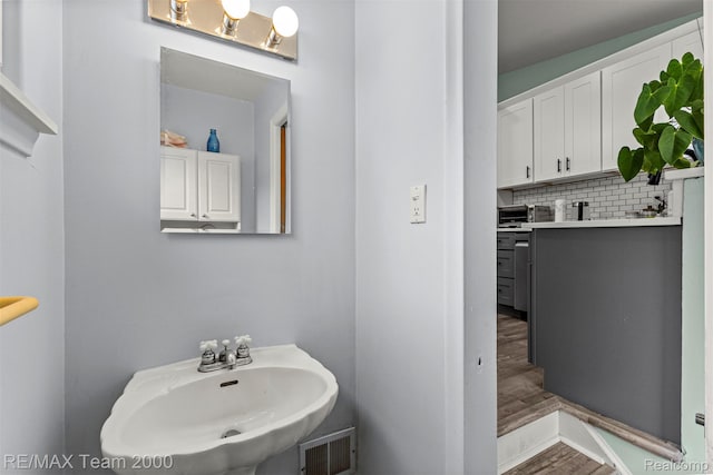 7396 N Charlesworth St, Dearborn Heights, MI 48127 - bathroom featuring wood finished floors and tasteful backsplash