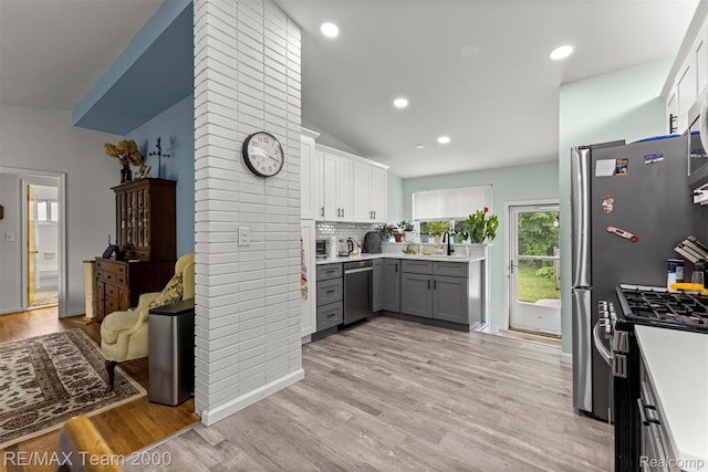 7396 N Charlesworth St, Dearborn Heights, MI 48127 - kitchen featuring appliances with stainless steel finishes, light countertops, gray cabinets, light wood-type flooring, and white cabinets