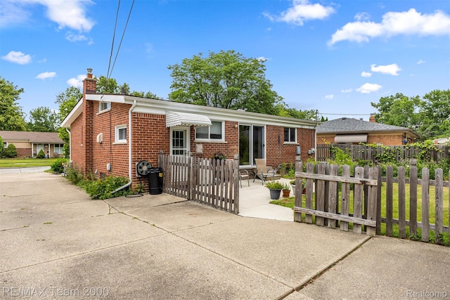 7396 N Charlesworth St, Dearborn Heights, MI 48127 - view of front facade with a chimney, brick siding, and a gate