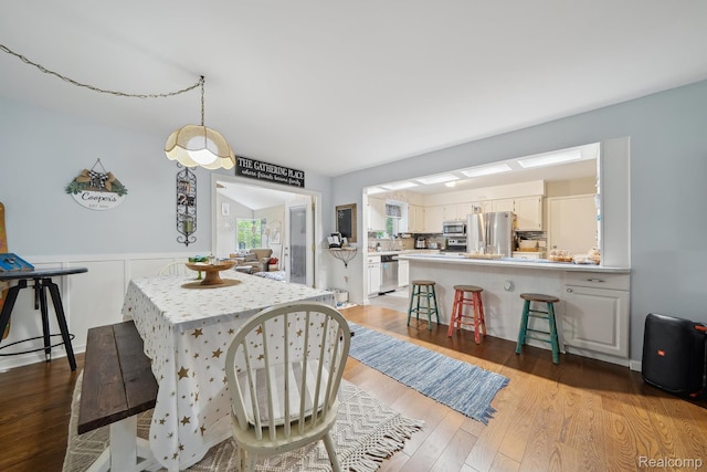 514 Sulley St, Waterford, MI 48327 - dining space with light wood-style flooring and wainscoting