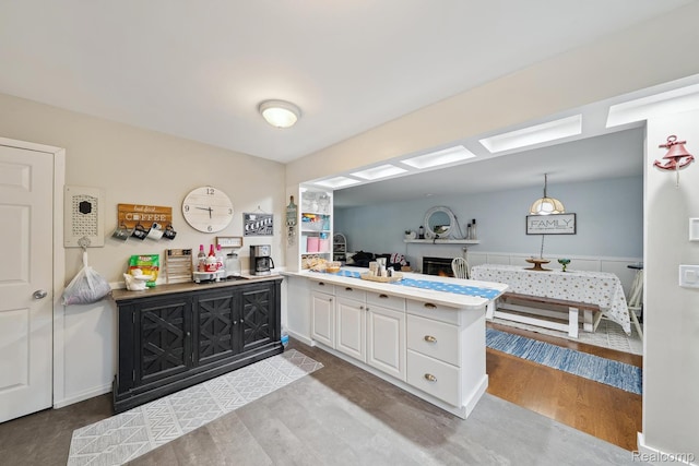 514 Sulley St, Waterford, MI 48327 - kitchen with a peninsula, wood finished floors, white cabinets, and light countertops