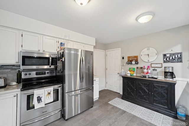 514 Sulley St, Waterford, MI 48327 - kitchen featuring appliances with stainless steel finishes, white cabinetry, light countertops, tasteful backsplash, and wood finished floors
