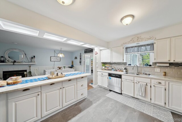 514 Sulley St, Waterford, MI 48327 - kitchen with dishwasher, light countertops, white cabinets, decorative backsplash, and a wainscoted wall