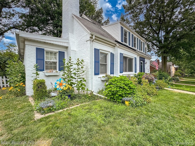611 N Melborn St, Dearborn, MI 48128 - view of side of home with a chimney, brick siding, and a yard