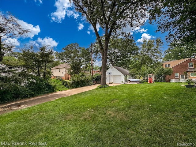 611 N Melborn St, Dearborn, MI 48128 - view of green lawn with concrete driveway, a garage, and an outdoor structure