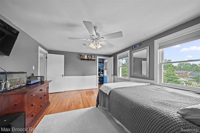 611 N Melborn St, Dearborn, MI 48128 - bedroom featuring light wood-type flooring, a walk in closet, and a ceiling fan
