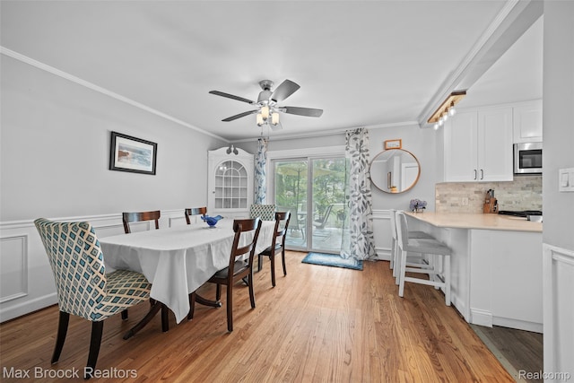 611 N Melborn St, Dearborn, MI 48128 - dining space with ornamental molding, light wood-type flooring, ceiling fan, and a wainscoted wall