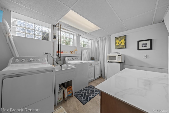 611 N Melborn St, Dearborn, MI 48128 - washroom featuring washer and clothes dryer, cabinet space, and light wood-type flooring