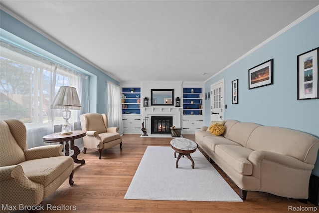 611 N Melborn St, Dearborn, MI 48128 - living area with wood finished floors, built in shelves, a fireplace with flush hearth, and ornamental molding