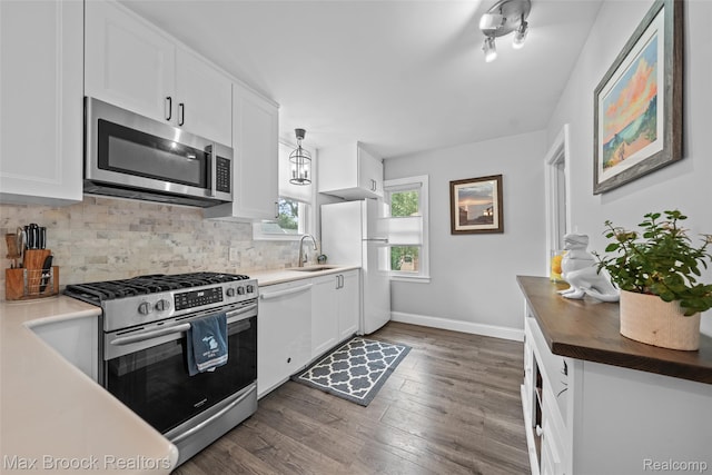 611 N Melborn St, Dearborn, MI 48128 - kitchen with stainless steel appliances, decorative backsplash, dark wood finished floors, and white cabinetry