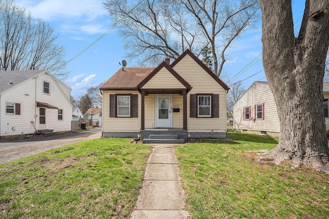 2820 Lowell St, Kalamazoo, MI 49001 - bungalow with a front lawn, a chimney, and a shingled roof