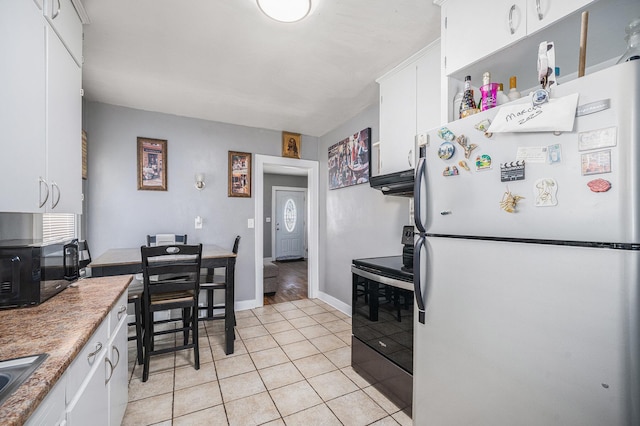 2820 Lowell St, Kalamazoo, MI 49001 - kitchen featuring freestanding refrigerator, electric range oven, white cabinets, light tile patterned floors, and black microwave