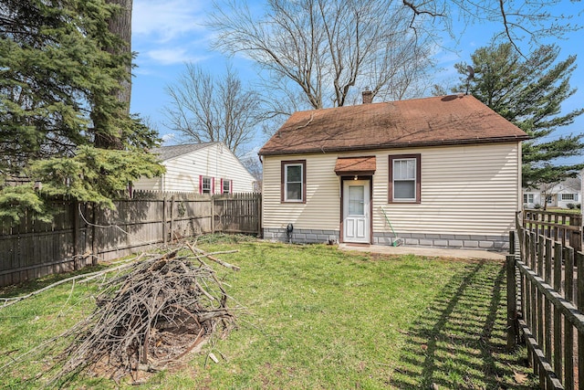 2820 Lowell St, Kalamazoo, MI 49001 - back of property with a fenced backyard, a chimney, and roof with shingles
