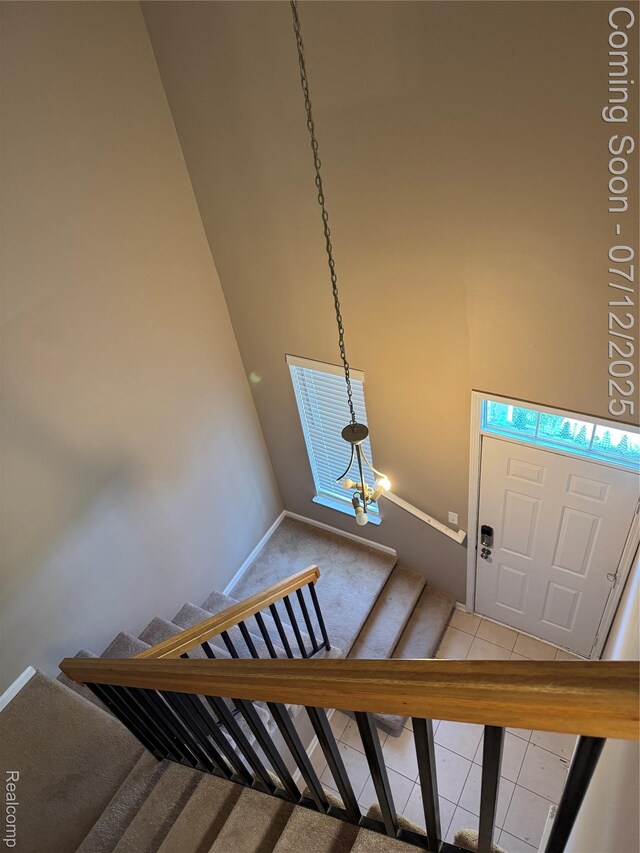 45562 Warwick Dr, Macomb, MI 48044 - staircase with a chandelier, carpet, and tile patterned flooring