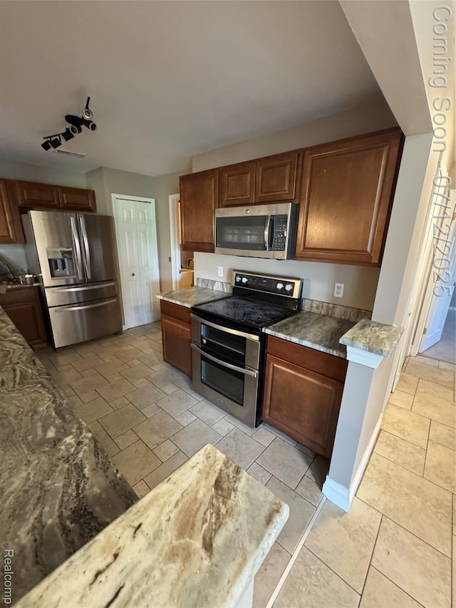 45562 Warwick Dr, Macomb, MI 48044 - kitchen featuring appliances with stainless steel finishes, stone countertops, and brown cabinets