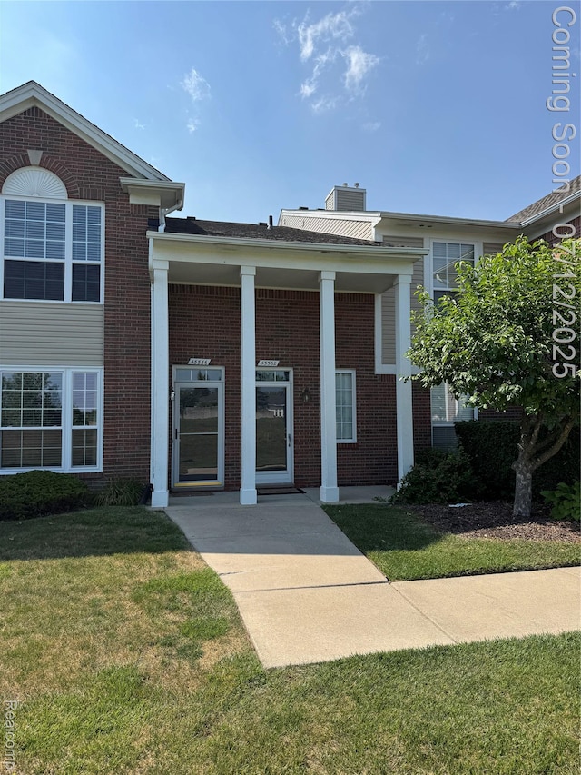 45562 Warwick Dr, Macomb, MI 48044 - entrance to property featuring brick siding, a yard, and a chimney