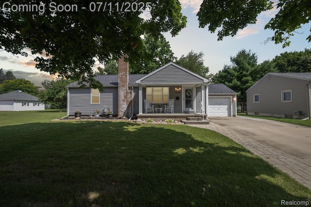 1338 W King St, Owosso, MI 48867 - ranch-style house with a porch, a chimney, a front lawn, concrete driveway, and a detached garage